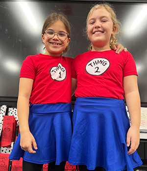 Two happy girls dressed as Thing 1 and Thing 2